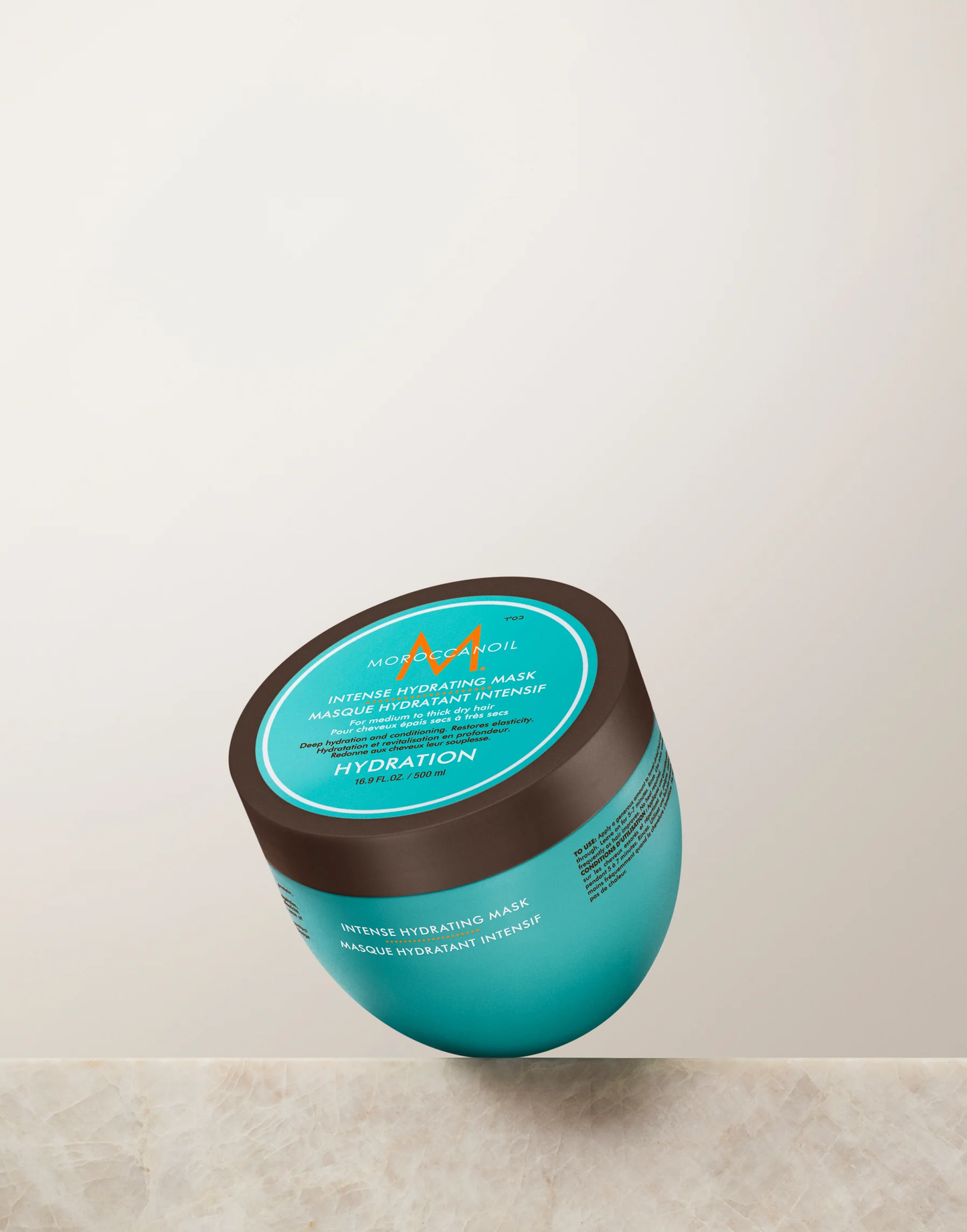 Blue hair mask jar with brown lid on a light gray background