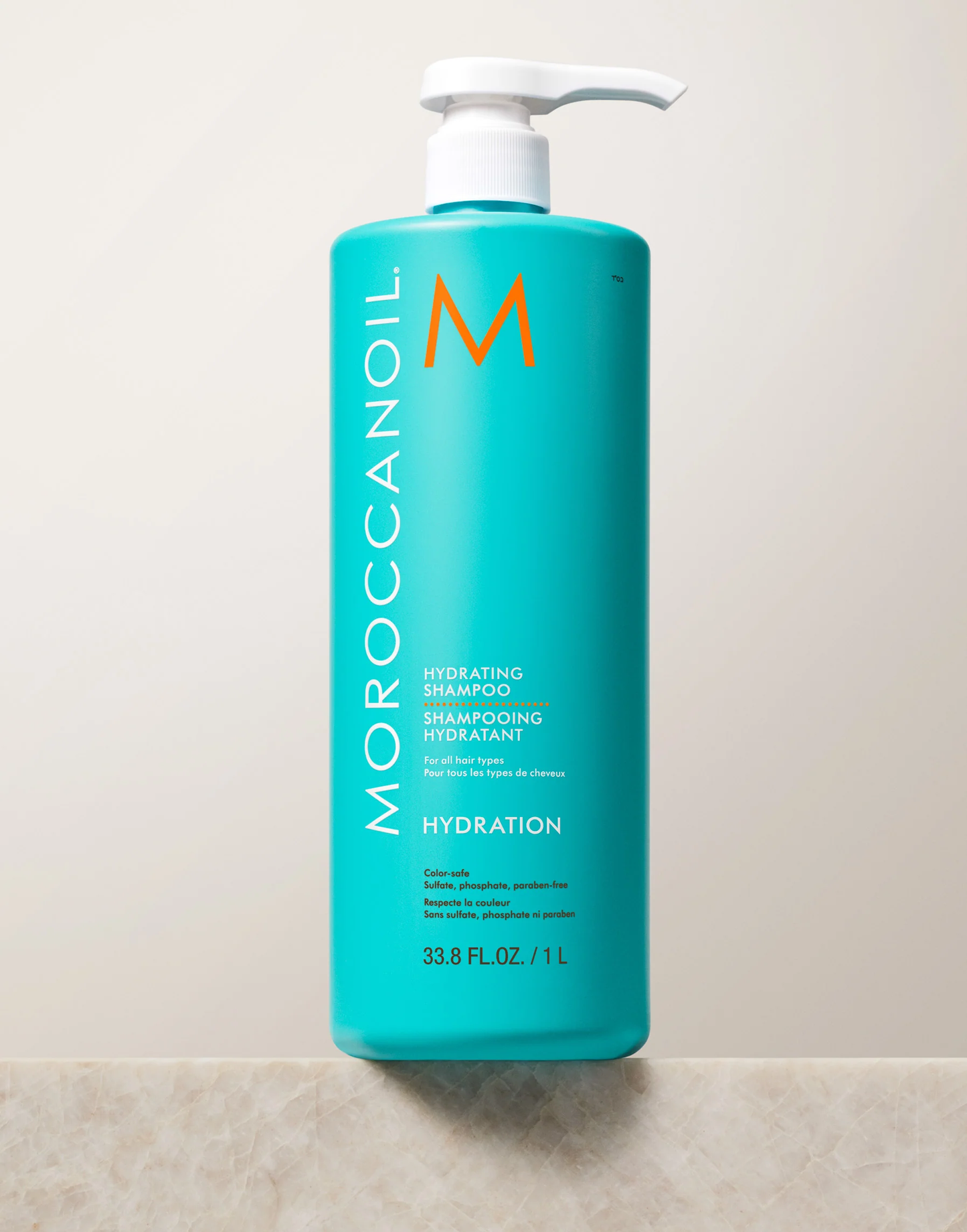 Moroccanoil shampoo bottle on a tiled bathroom wall