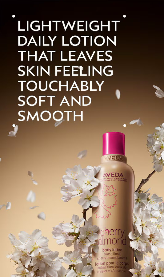Aveda Cherry Almond body lotion with cherry blossoms on a dark background.Aveda Cherry Almond Body Lotion 6.7oz bottle, moisturizing lotion that hydrates skin, leaving it soft, smooth, and delicately scented with cherry almond.