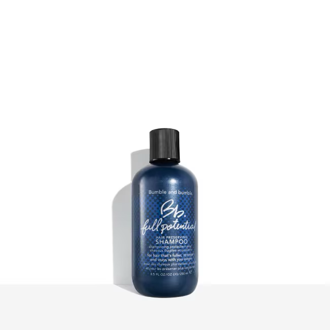 Bottle of Bumble and Bumble shampoo on a white background. Bumble and Bumble Full Potential Shampoo 8.5oz bottle, strengthening shampoo that nourishes hair, improves resilience, enhances shine, and promotes healthier, fuller-looking strands.