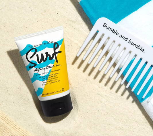 Bumble and bumble Surf styling leave-in product with a comb on a beige background. Bumble and Bumble Surf Styling Leave-In 2oz bottle, lightweight leave-in treatment that adds texture, volume, and beachy waves while enhancing softness and shine