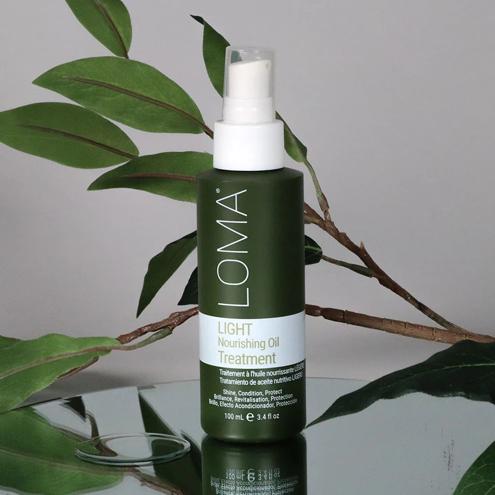 LOMA light nourishing oil treatment bottle with green leaves in the background