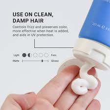 Hand applying a blue hair care product to clean, damp hair with text on a white background. Loma Smoothing Créme 8oz jar, hair cream that tames frizz, smooths strands, adds shine, and leaves hair soft, sleek, and manageable.
