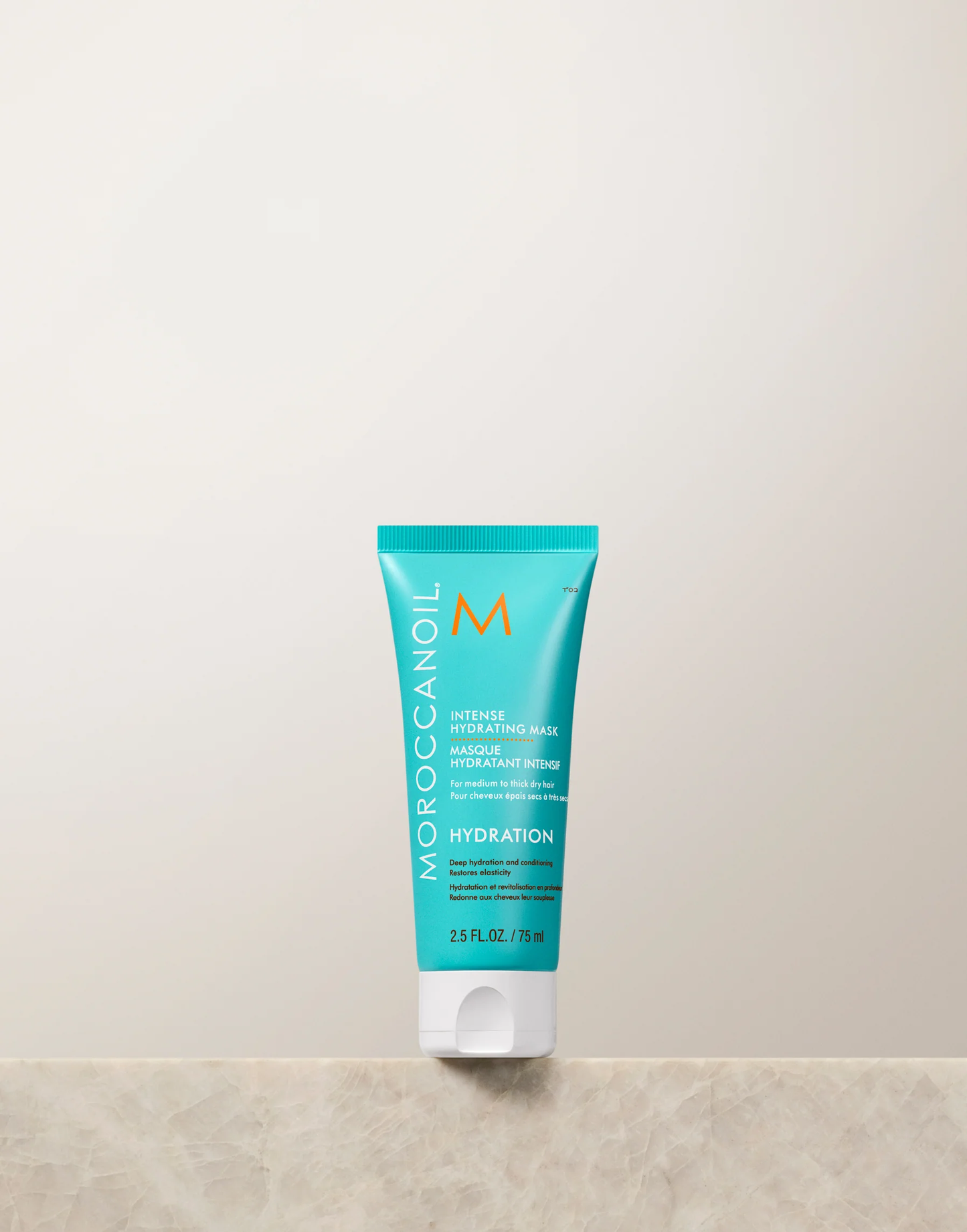 Moroccanoil hydration product on a beige surface with a light gray background