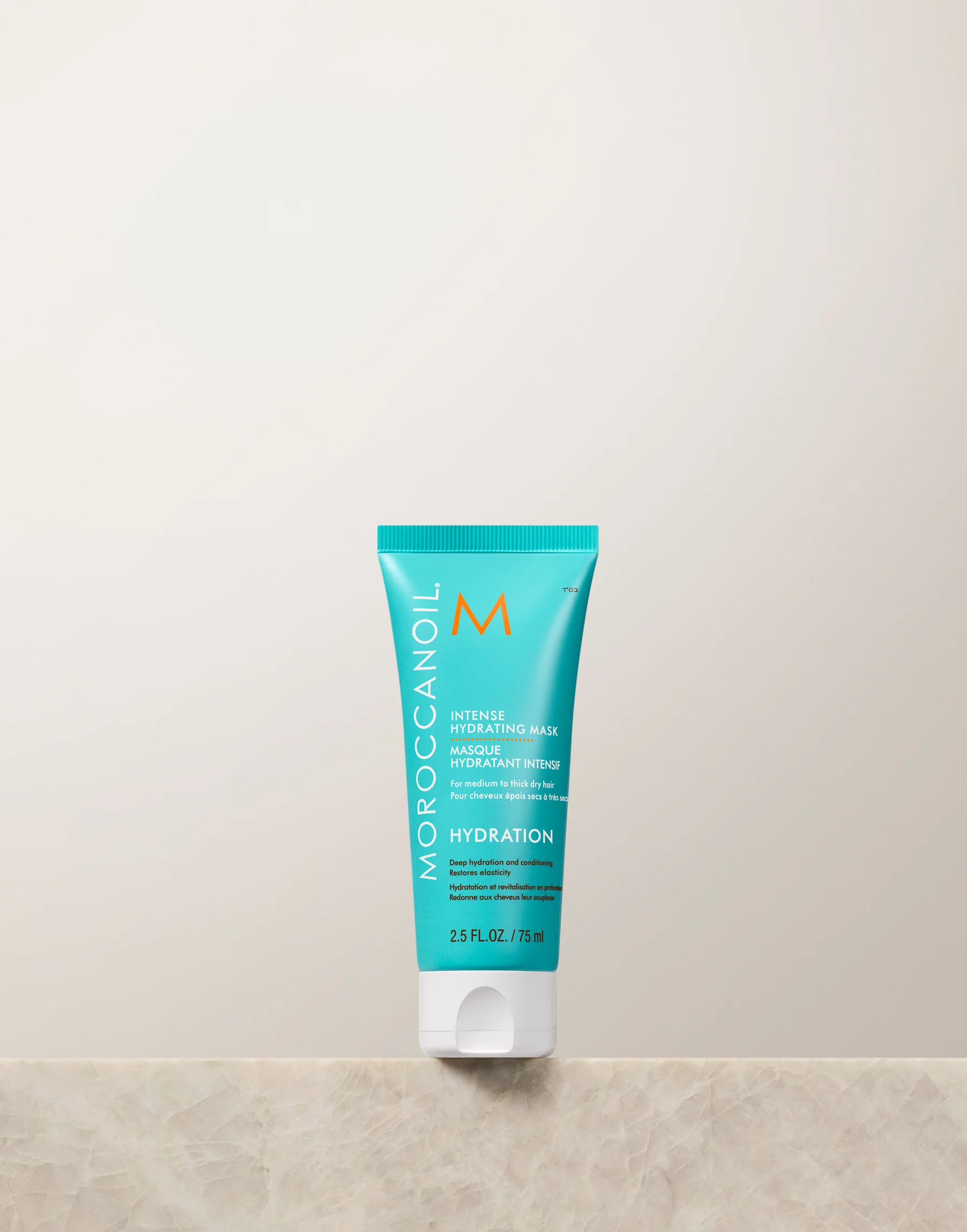 Moroccanoil hydration product on a beige surface with a light gray background