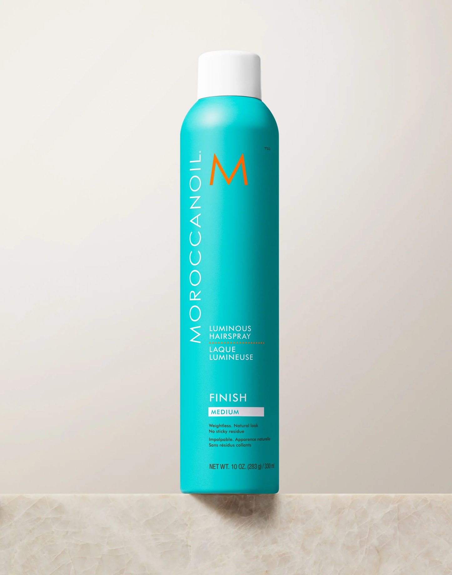 Moroccanoil hair spray bottle on a light background