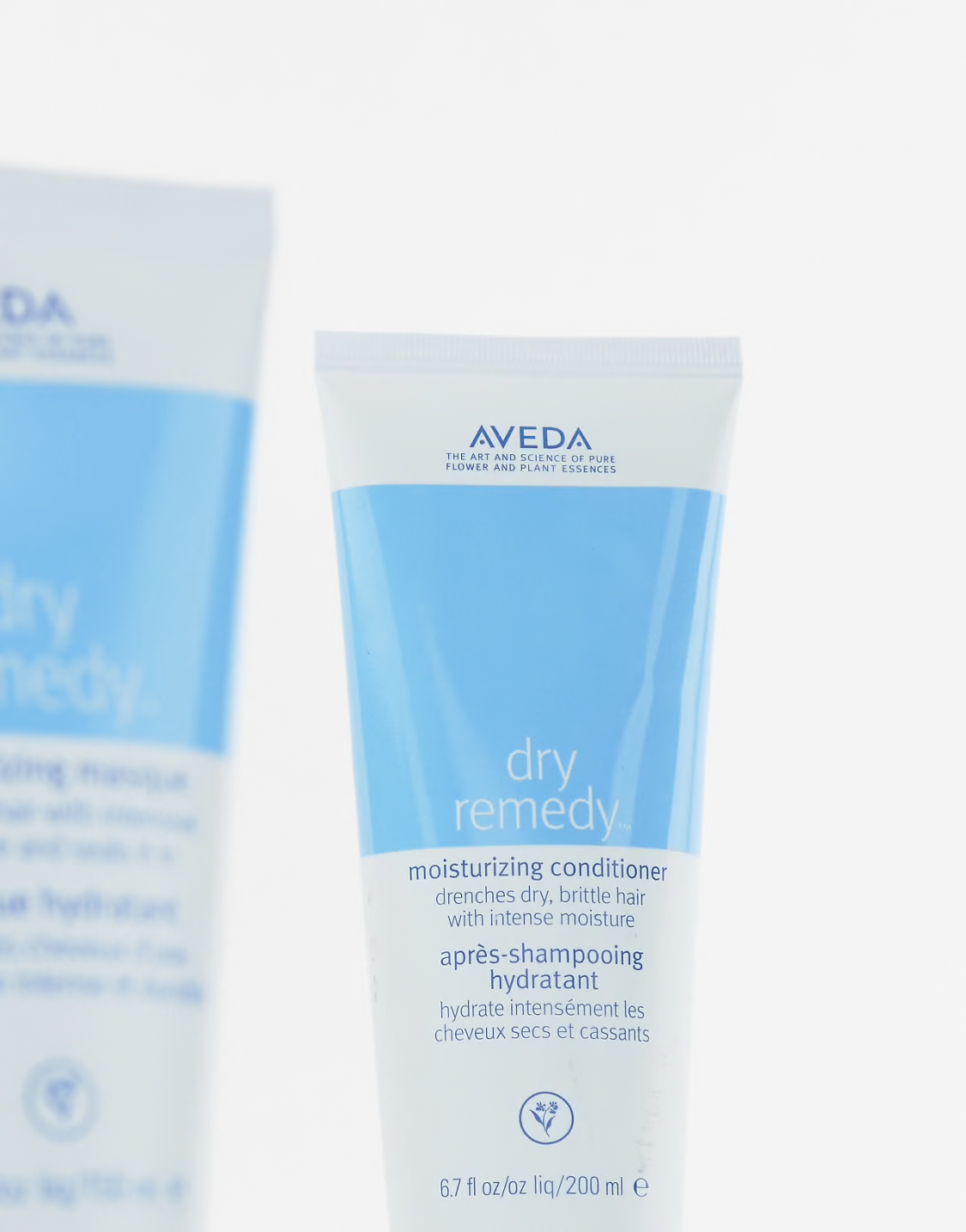 Two Aveda dry remedy moisturizing conditioners on a white background. Aveda Dry Remedy Moisturizing Conditioner 6.7oz bottle, rich conditioner that deeply hydrates dry hair, restores softness, smoothness, and improves manageability.