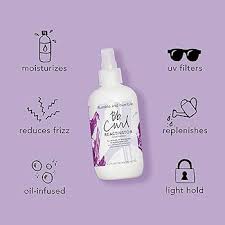 White spray bottle with purple label on a light purple background with icons and text. Bumble and Bumble Curl Reactivator 8.5oz bottle, lightweight spray that refreshes and reactivates curls, reduces frizz, and restores bounce, definition, and shine.