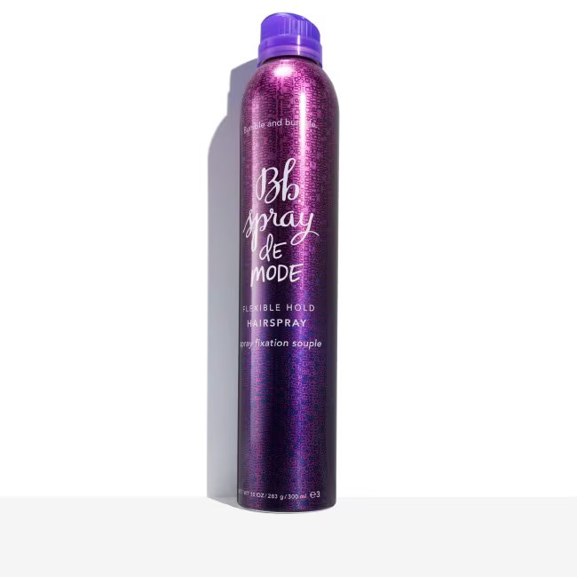 Purple hairspray can with 'Bb spray de mode' text on a white background.Bumble and Bumble Spray de Mode Flexible Hold Hairspray 10oz can, lightweight styling spray that provides flexible hold, natural movement, and shine.
