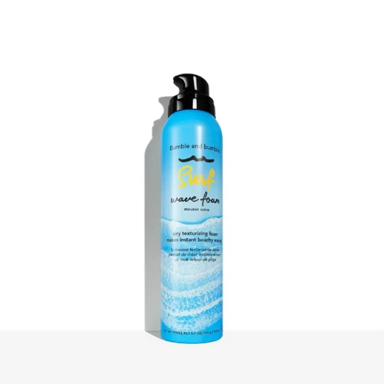 Blue bottle of hair product with black pump on a white background. Bumble and Bumble Surf Wave Foam 5oz can, lightweight styling foam that creates soft, textured, beachy waves while enhancing body, movement, and shine