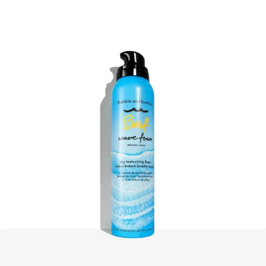 Blue bottle of hair product with black pump on a white background. Bumble and Bumble Surf Wave Foam 5oz can, lightweight styling foam that creates soft, textured, beachy waves while enhancing body, movement, and shine