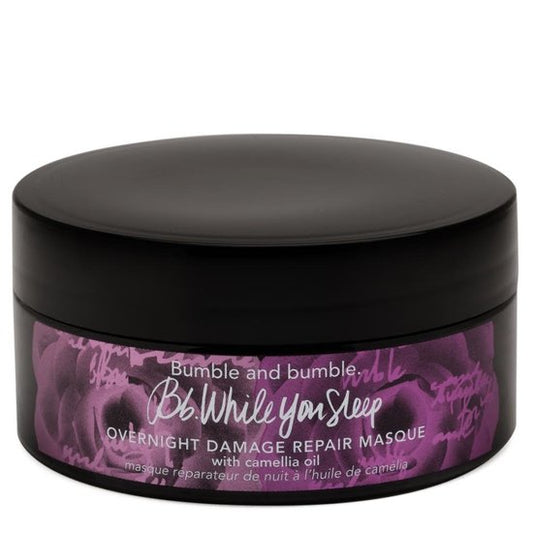 Black jar of Bumble and Bumble 'While You Sleep' overnight damage repair masque with purple label on a white background. Bumble and Bumble While You Sleep Overnight Hair Repair Mask 6.4oz jar, intensive treatment that repairs, nourishes, and restores damaged hair while you sleep