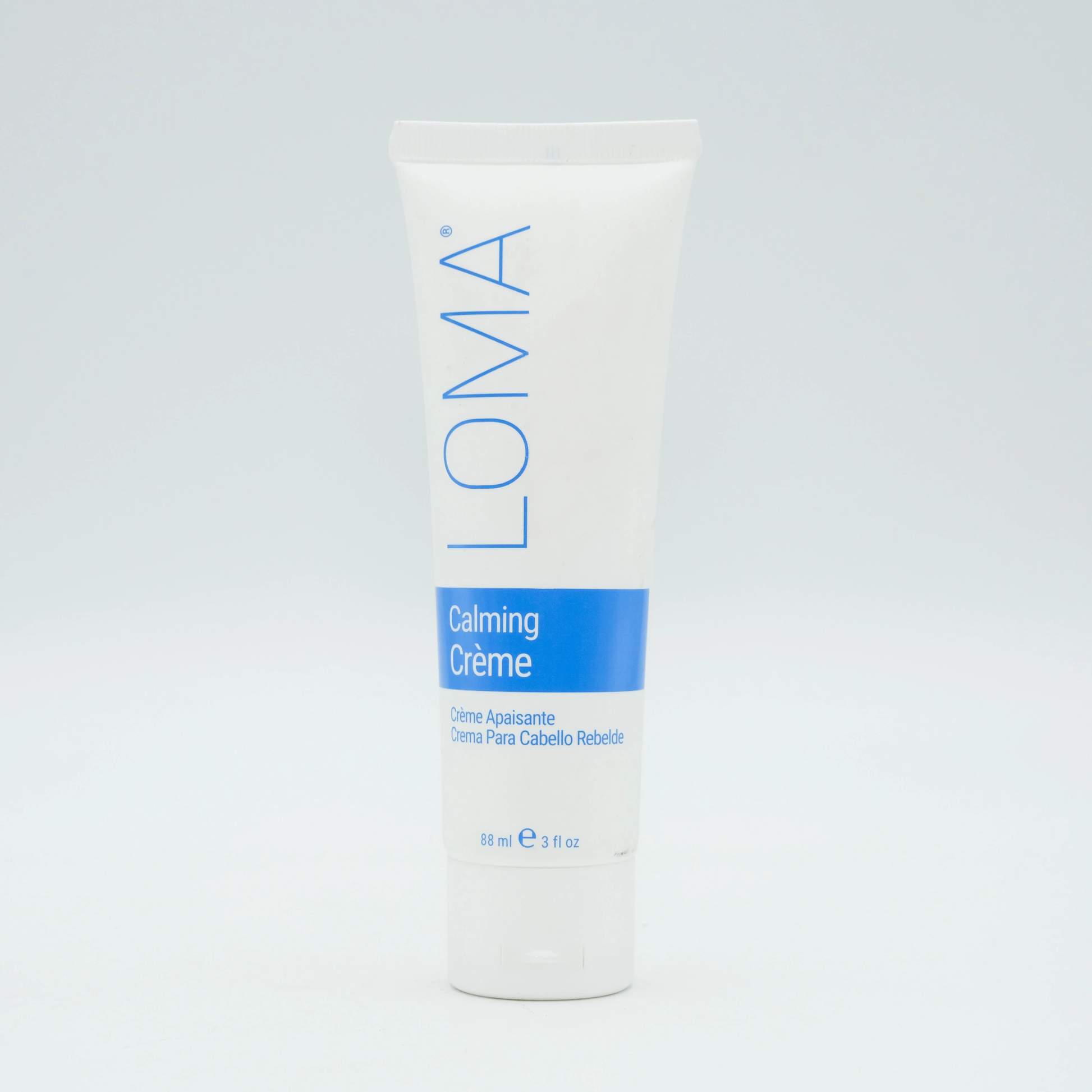 Loma Calming Creme container on a light gray background. Loma Calming Creme 3oz jar, soothing hair treatment that calms the scalp, nourishes strands, and restores softness, moisture, and manageability.