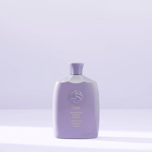 Purple shampoo bottle with brand logo on a light purple background. Oribe Serene Scalp Oil Control Shampoo, gentle cleansing shampoo that removes excess oil, soothes the scalp, and leaves hair refreshed, clean, and healthy.