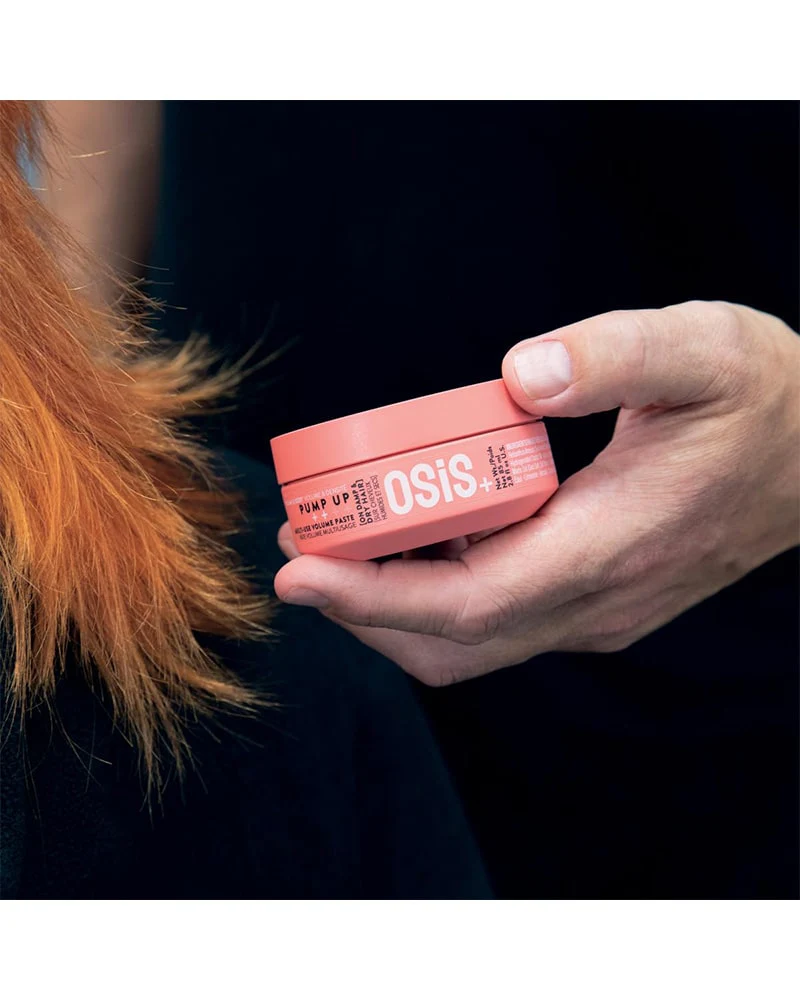 Person holding a Schwarzkopf ‘Pump It’ Multi-use Volume Paste 2.8oz jar, styling paste designed to add texture, lift, and long-lasting volume to hair.